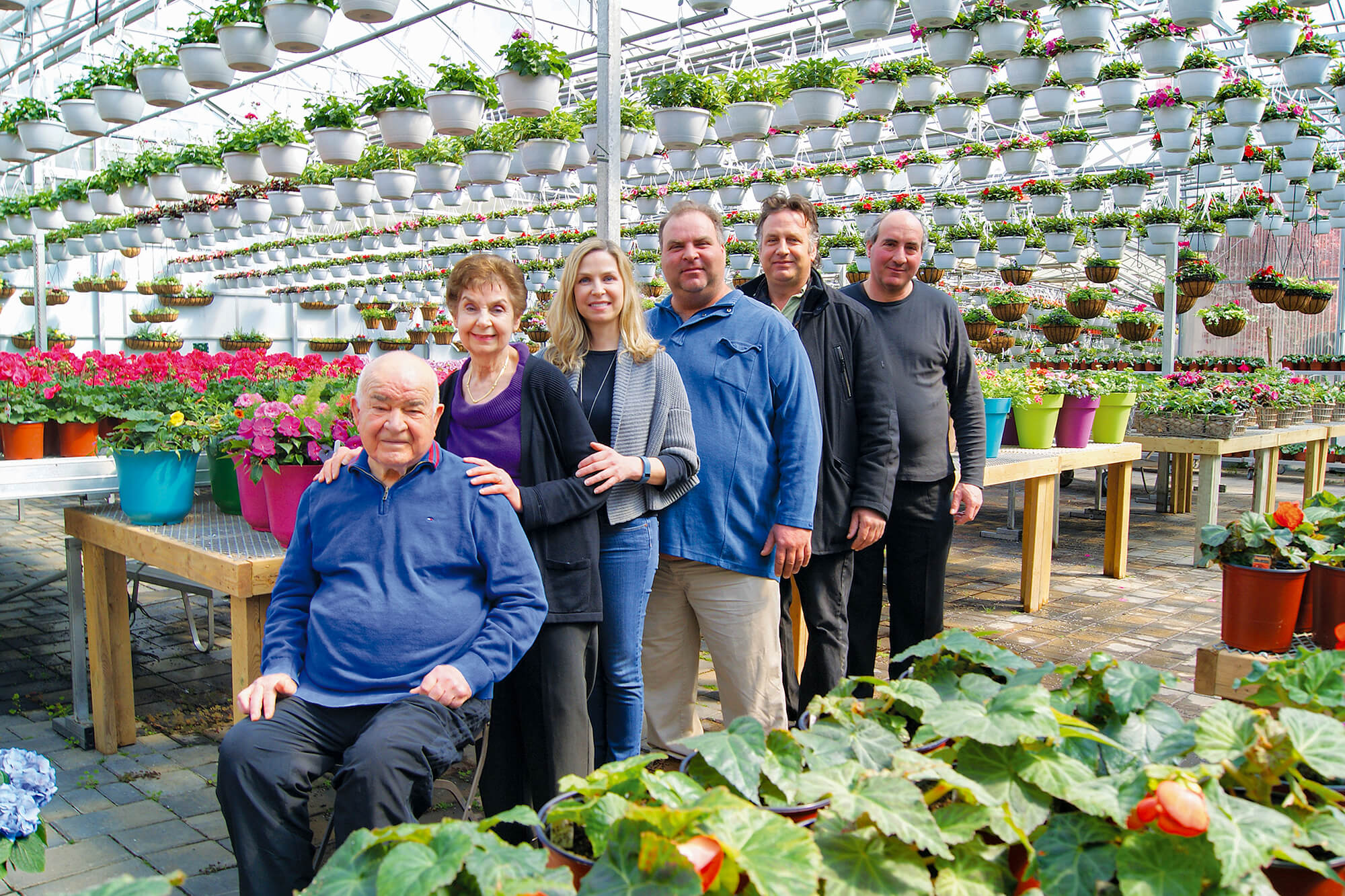 family all togehter in a greenhouse full of colourful plants