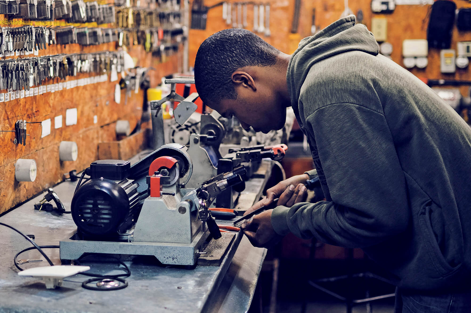 young man using a grinder on a bench